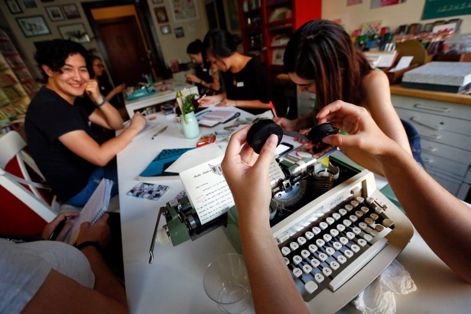 Margaret Haas, right, changes the ribbon on her typewriter as she types a letter to a pen pal during the monthly gathering of the L.A. Pen pal Club, where members share a love affair with old-fashioned stamps and envelopes.