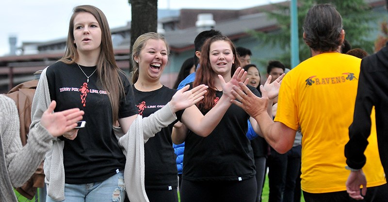 The Terry Fox secondary Link Crew cheers on the first runners back from the Terry Fox school run Thursday.
