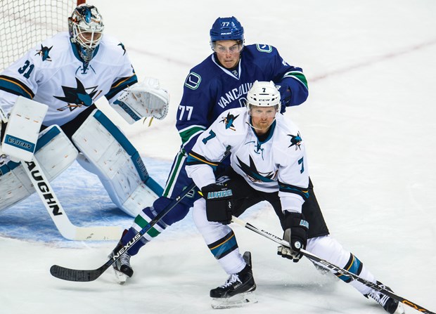 Martin Jones follows the play as Vancouver’s Jake Virtanen battles Paul Martin during NHL preseason action Tuesday at Roger’s Arena. The North Vancouver goalie picked up a shutout in his first game since San Jose picked him up in a trade this summer.