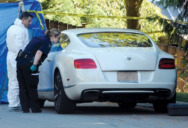 North Vancouver RCMP and IHIT investigators inspect the inside of a Bentley at the scene of a homicide in Lynn Valley. photo Mike Wakefield, North Shore News
