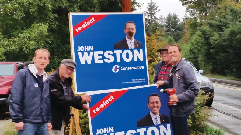 Conservative Party supporters Michael Fryer, Lauri Pearce and Bob Whittle help incumbent MP John Weston replace one of his campaign signs that have been defaced on the Coast during this election.