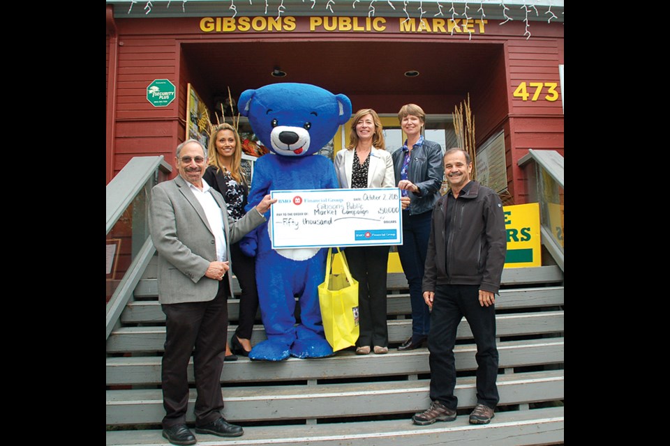 Pictured from left to right are: Gibsons Public Market capital campaign co-chair Gerry Zipursky, Gibsons Bank of Montreal (BMO) branch manager Natasha Johal, the BMO Bear, BMO regional vice president for the North Shore and Sunshine Coast Pat Dejong, market capital campaign co-chair Pam Robertson and Gibsons Mayor Wayne Rowe with a $50,000 cheque from BMO to help aid in the creation of the Nicholas Sonntag Marine Education Centre at the expanded Gibsons Public Market.