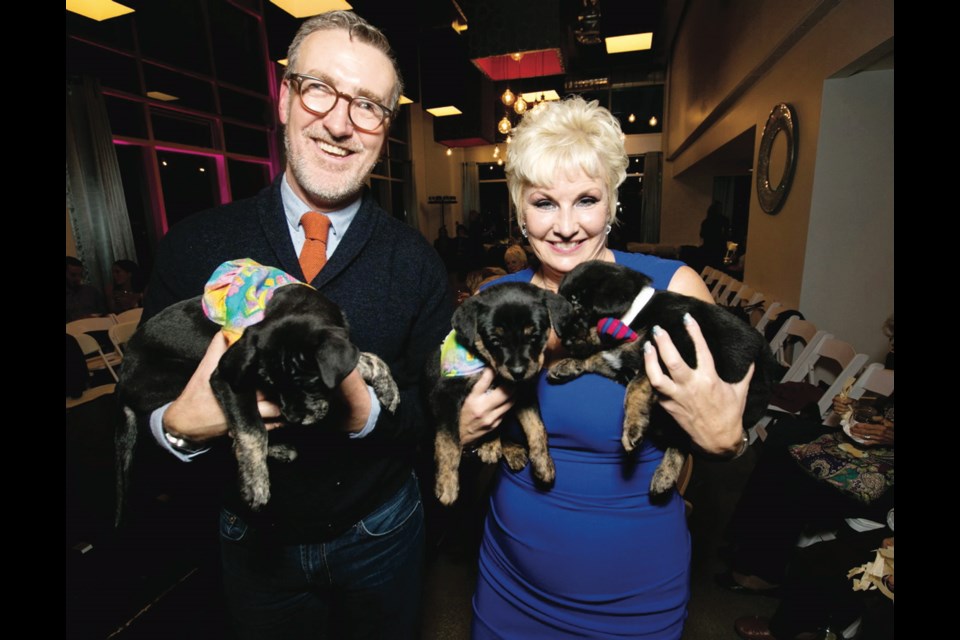 Outlooks for Men owner Dale Olsen and Victoria Humane Society executive director Penny Stone share a trio of puppies at Man and His Dog.