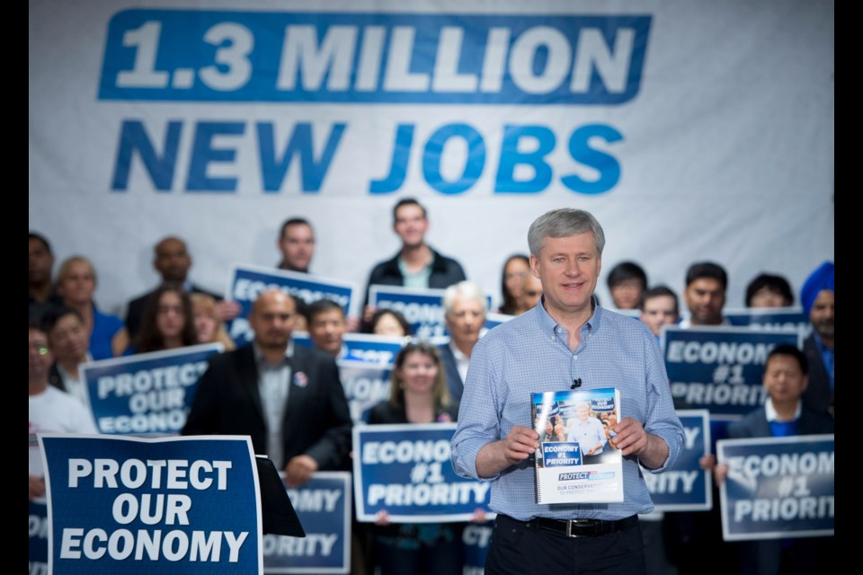 Conservative leader Stephen Harper holds a copy of his party's platform during a campaign stop in Richmond, B.C. Thursday, Oct. 9, 2015.