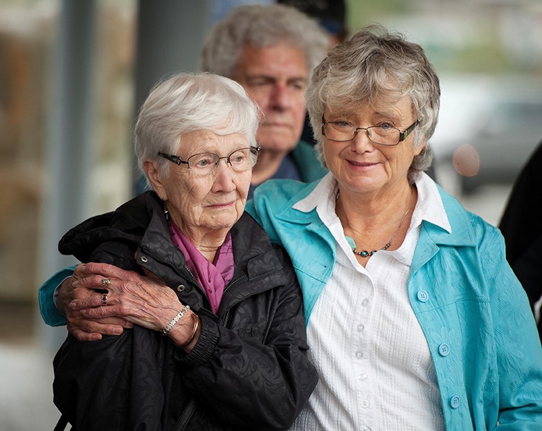 Marnie Melnyk comforts her mother Rita Dickie at the unveiling of a memorial bench on Saturday in O’Siyam Pavilion Park. The bench is in memory for their late husband and father, Geordie Dickie, as well as Don Dickie, Geordie’s brother. Both were killed in logging accidents.