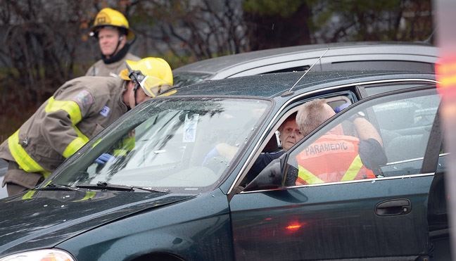 Emergency crews assist the driver and passenger of one of three vehicles involved in a crash at 15th Avenue and Carney Street Wednesday morning.