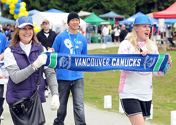 Sandra Buckley and daughter Cassandra support the Canucks as they complete a lap at the Relay For Life at Mahon park.