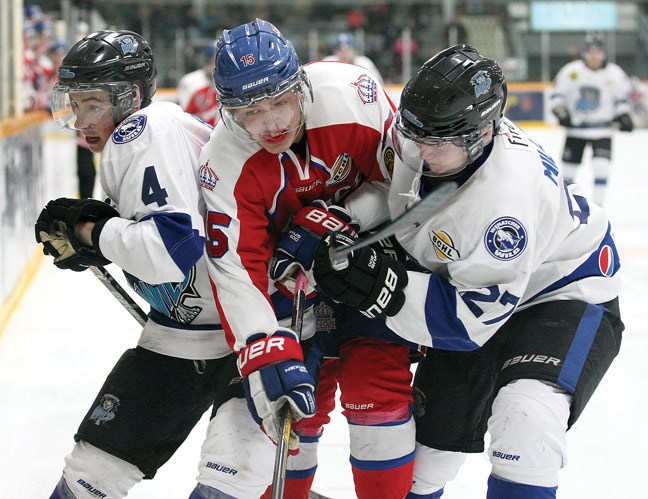 Kyle Johnson (centre) reaches for the puck as he is sandwiched between Matthew Baker (left) and Logan Milliken (right) as the Prince George Spruce Kings took on the Wenatchee Wild on Friday at the Coliseum.