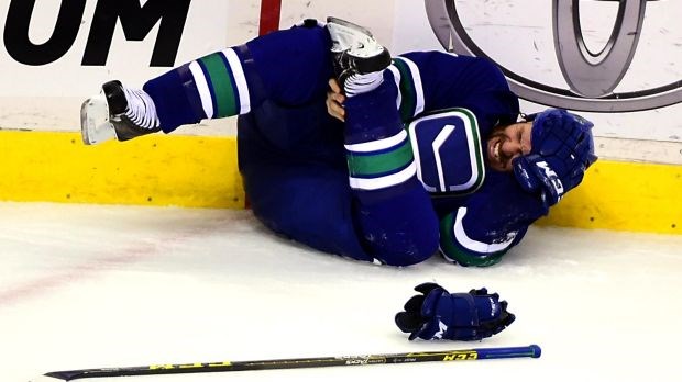 Brandon Prust grimaces in pain while holding his injured ankle.