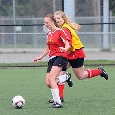 Carson Graham (yellow) and West Vancouver (red) at Carson's field in action in their first senior girls soccer match of the season.