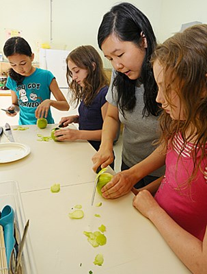 L-R Annie Partridge (12), Katrina Padula (12), Alethea Cahm and Rachel Johnson (10) peel and cut apples for mini apple pies.