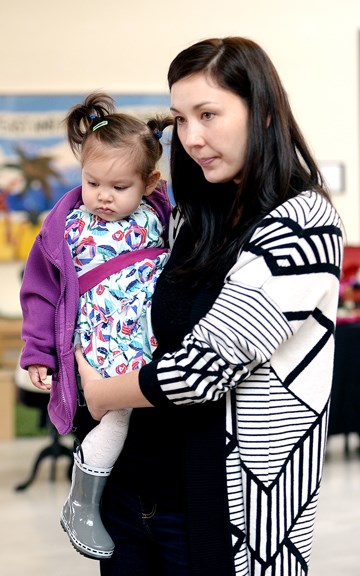 Alana Lopez and 16-month-old Cecelia check out some of the offerings at the New West Moms group's Christmas fundraiser at the River Market.