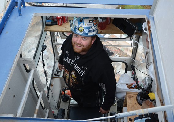 TOWER Crane operator Tyler Strachan (right) stands inside the cab of the
SK400, 180 feet above a highrise construction site at 17th and Lonsdale.