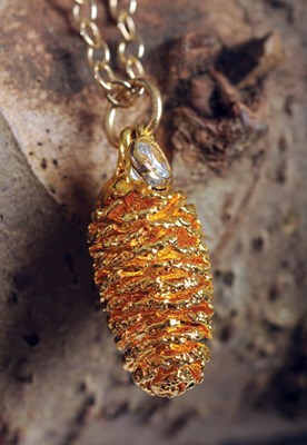 Pieces, such as the gold pine cone necklace, combine the raw wilderness of the West Coast with chic city life.