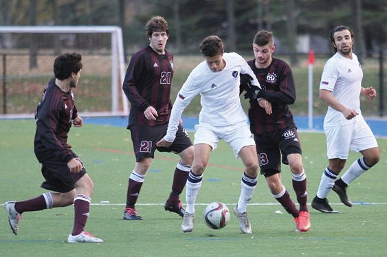 Kristian Yli-Hietanen of the Capilano Blues takes on a pair of defenders at the CCAA national championships while teammate Kamyar Amini provides support. The Blues ended a wild season by finishing second at nationals in Saint-Lambert, Que.