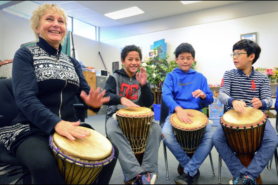 Music teacher Geraldine Lazaruk and students, from left, Sateki Vikilani, Nigel Giaglogo and Andrew Lee practise an Africa rhythm on a set of djembe drums at Marlborough Elementary School Thursday. The school hosts a 12-hour drum-a-thon next week to raise money for Syrian refugees