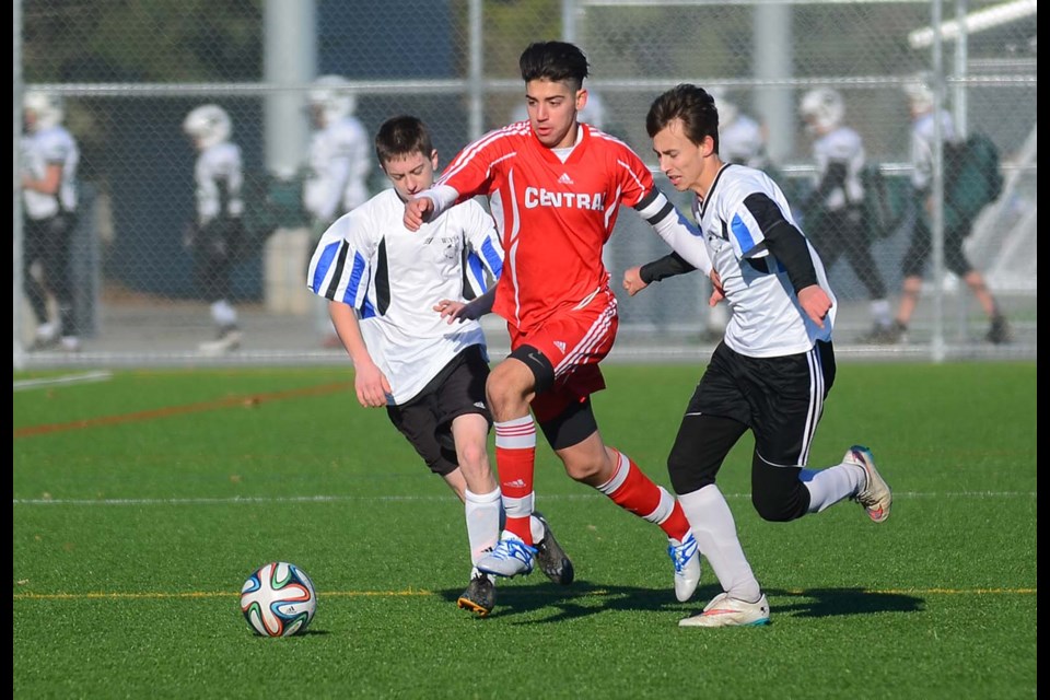 Pushing past two Lake City rivals, Burnaby Central's Fonz Marano drives to the goal during last week's B.C. AAA boys soccer championships at Burnaby Lake.