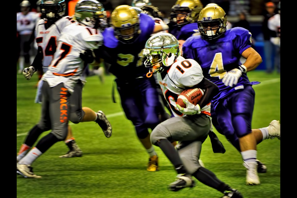 New Westminster's David Penalver dashes through the line during first quarter action of the B.C. Subway Bowl semifinal against Vancouver College at BC Place.
