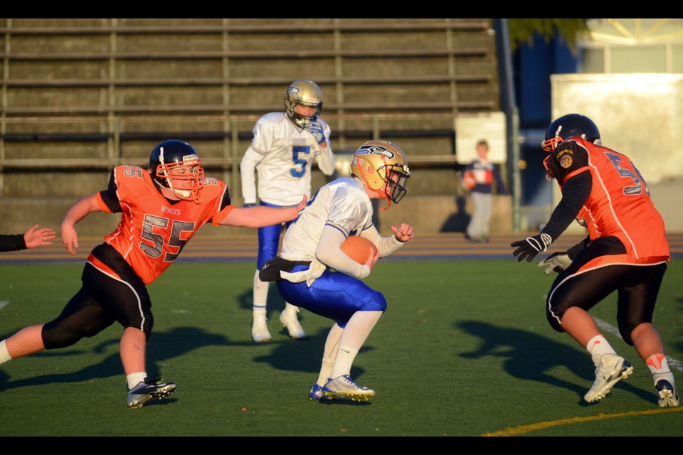 New Westminster defenders Anthony Dillman, at left, and Isaiah James, far right, prepare to close down a Seaquam rush during last week's B.C. AAA junior football semifinal.