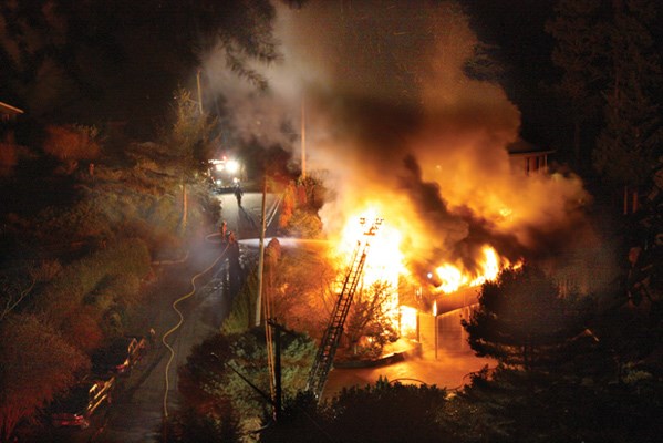 A West Vancouver waterfront home on Copper Cove Road is completely engulfed
in flames as firefighters work to control the fire Sunday night. Nobody was
in the home at the time.