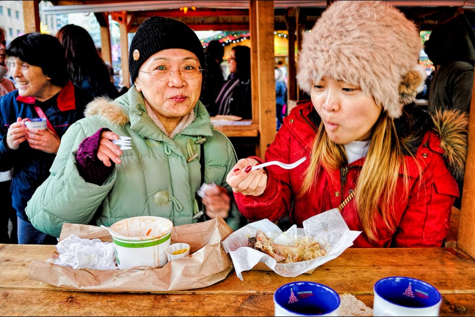 Tracy Lui (left), who came over from Taiwan to visit her daughter Cherrie Miao (right), tries some borscht while her daughter takes a bite of pig feet. Photo Chung Chow