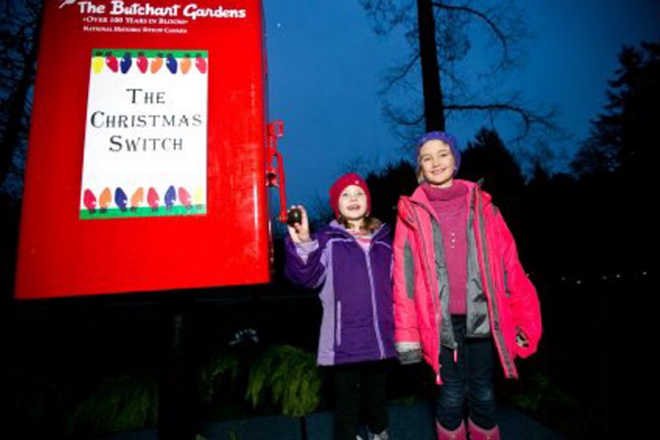 Jordyn Skidmore, 7, and Devyn Skidmore, 9, at the master switch for Butchart Gardens&Iacute; Magic of Christmas light display.