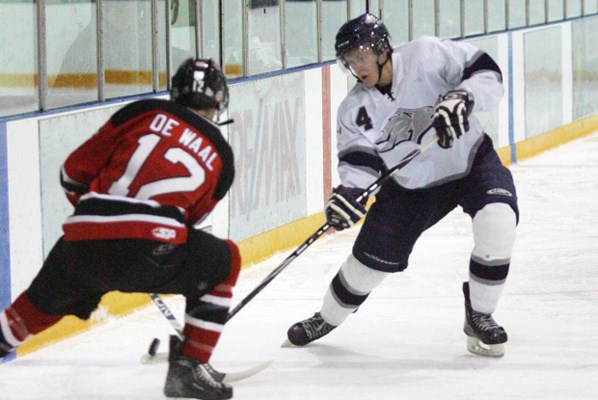 Wolf Pack defender Benjamin McWilliams moves the puck up the boards.