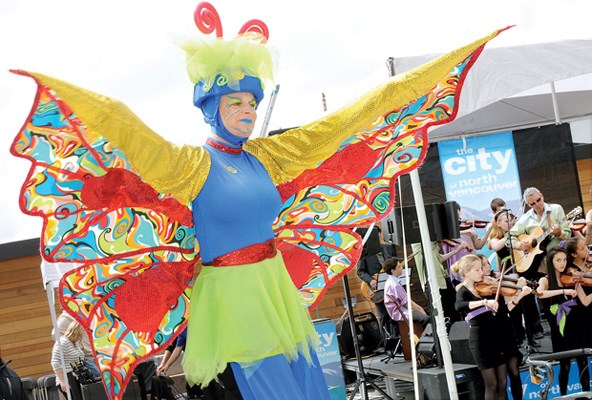 A stilt walking butterfly performer dances to the sounds of the North Shore Celtic Ensemble at the City of North Vancouver's Civic Plaza Celebration event.