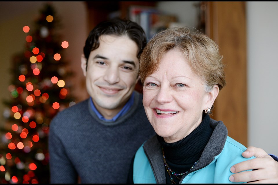 Mohammed Alsaleh and Deana Brynildsen at her home in New Westminster. Brynildsen read about Alsaleh, a refugee from Syria, in the Record, and invited him over to meet her friends. Now she’s crowdfunding to help bring his family to Canada.