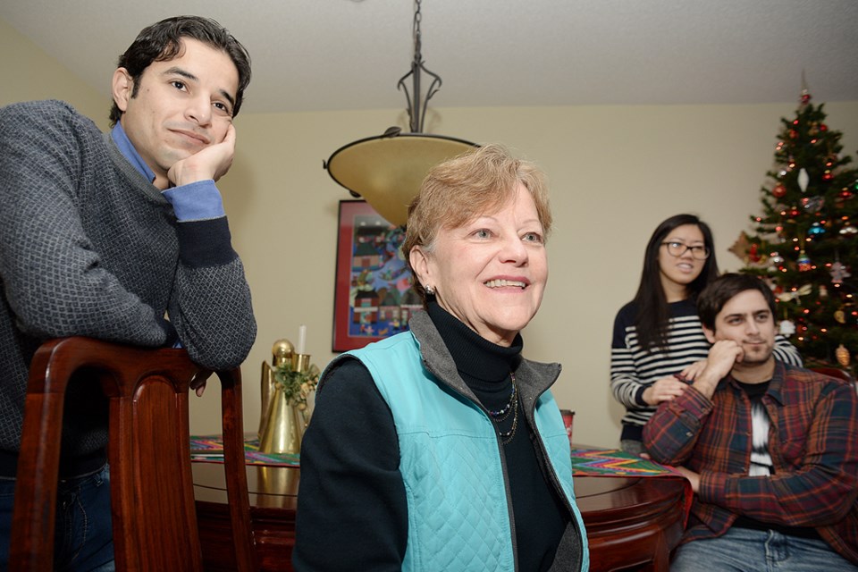 Mohammed Alsaleh, Deana Brynildsen, Lillian Wing and Tiago Palma watch local news coverage of a Burnaby father being reunited with his Syrian sons after 15 years of separation. Alsaleh was at the airport to help with translation.