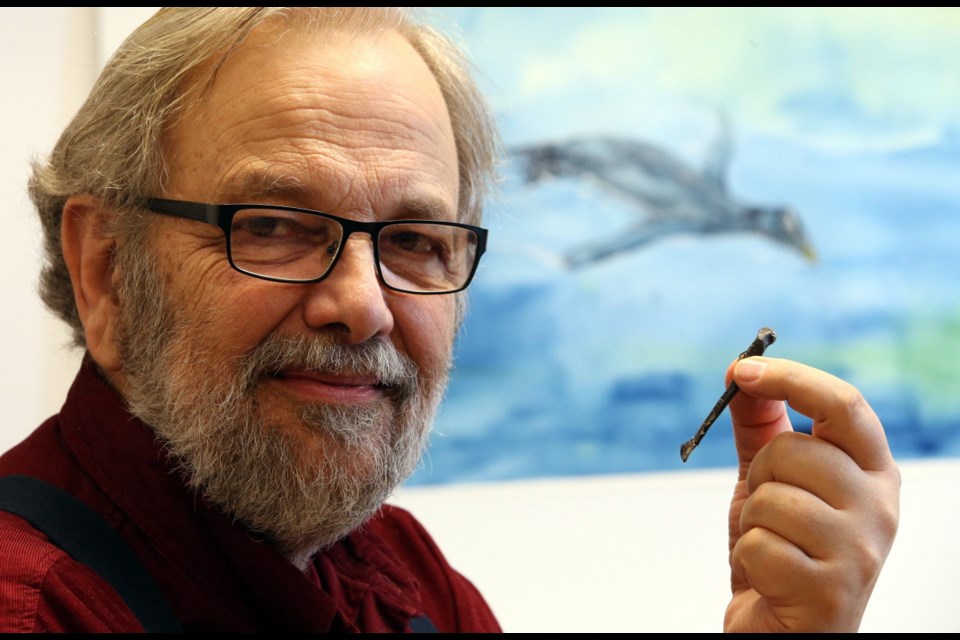 Gary Kaiser, a research associate at the Royal B.C. Museum, holds the fossilized collarbone of a flightless bird he named Stemec suntoku, a penguin-like creature that lived 23 million years ago.