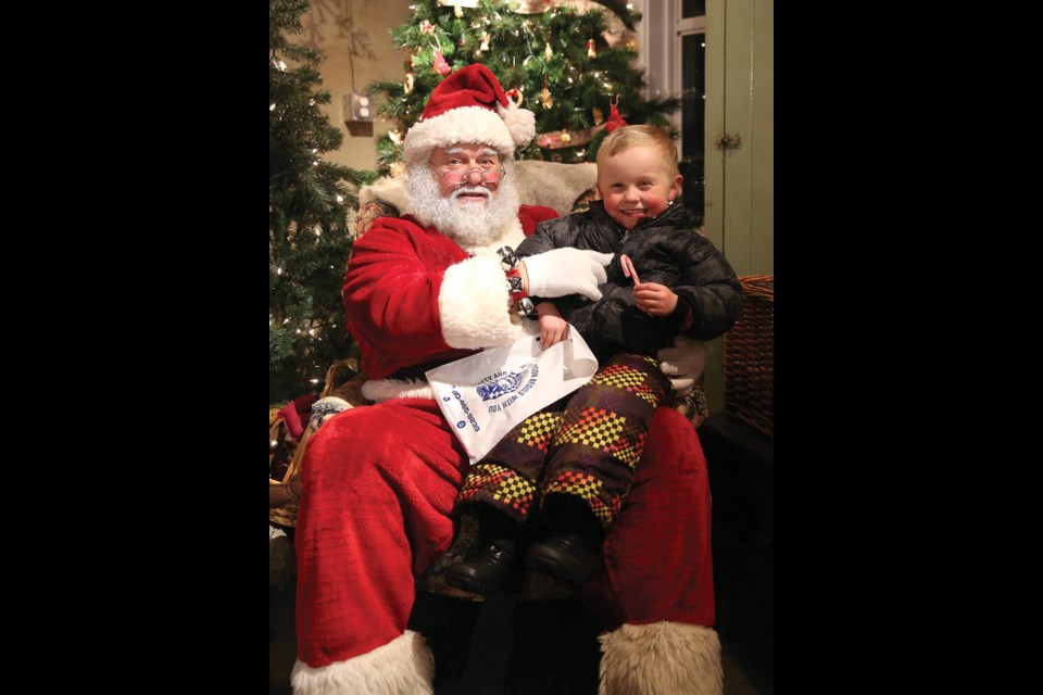 A rosy cheeked Sawyer Seinen, 4, is all smiles as he sits with Santa at The Railway and Forestry Museum during the annual Celebration of Lights on Tuesday. Citizen Photo by James Doyle December 22, 2015