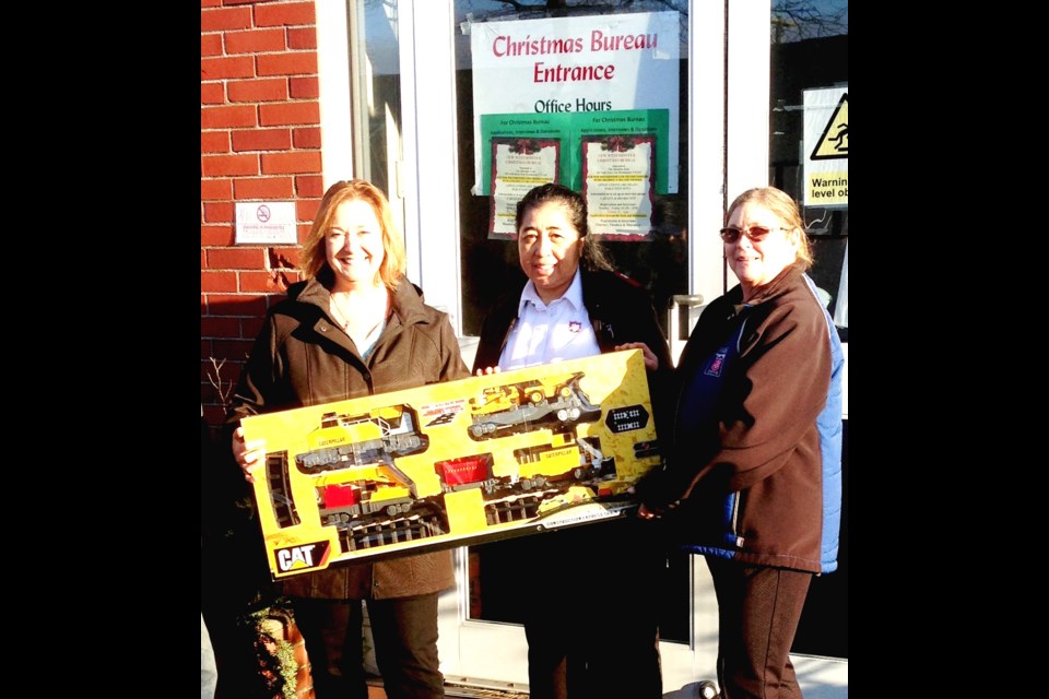Southern Railway of B.C. manager Joanne Kreiter, left, presents one of the many toys the railway employees donated to the Salvation Army, which runs the local Christmas Bureau and a food bank. Food bank coordinator Lyn Thompson, right, and Salvation Army Pastor Eva Galvez appreciate the donations.