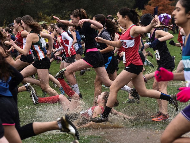 SLIP N SLIDE: A downpour at Jericho Beach Park on Nov. 7 during the B.C. high school cross-country championships soaked the terrain, and the sodden, slippery course lead to a few spills out of the gate, like this one during the senior girls race. A downed runner in a sea of legs shows how the event became an obstacle course as racers fought to keep their footing.