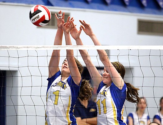 Handsworth players block ball(white) in Lower Mainland Volleyball playoffs action against West Vancouver.