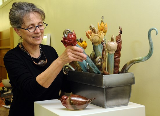 Delbrook Pottery Studio manager Louisa Leibman arranges her Raku fired flowers displayed during the North Shore Art Crawl, held over the weekend of April 21st & 22nd. 200 artists over 50 locations opened their studio spaces for a weekend of free public viewing.