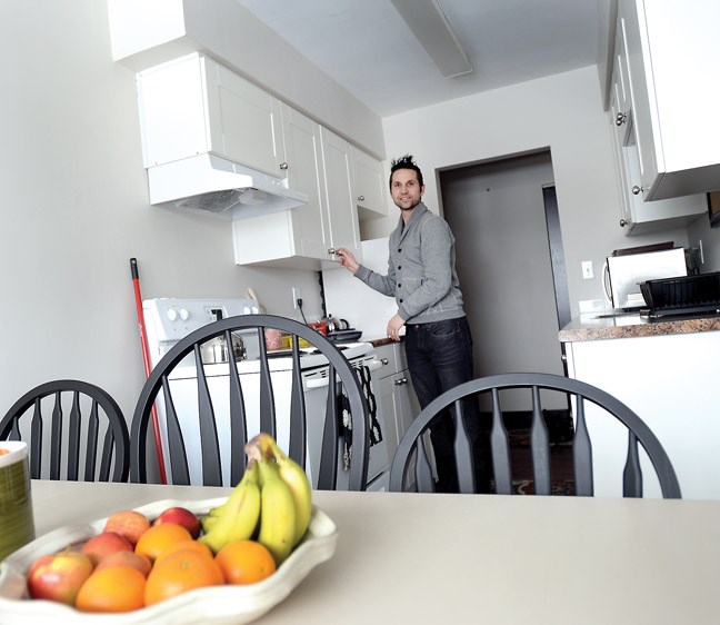 Ryan Beer, part of the Westwood Church organizing committee, puts food away in the kitchen that will be home to a Syrian family that is arriving in Prince George on Thursday.