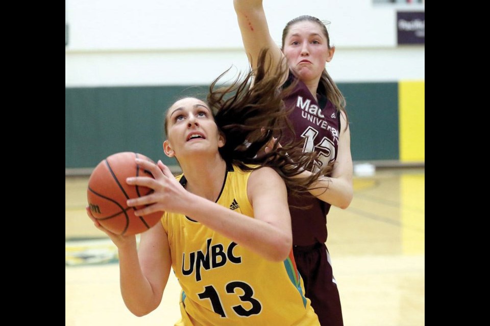 UNBC Timberwolves Vasiliki Louka tries to shoot around the outstretched arms of MacEwan University Griffins Kelly Fagan on Friday at the Northern Sport Centre. The Griffins, with a record of 7-1 heading into the game, were in town to take on the Timberwolves, who had a record of 1-7 and after the final whistle, the Griffins walked away with a 73-58 victory. The same two teams will meet again on Saturday at 6pm at the Northern Sport Centre. Citizen Photo by James Doyle      January 8, 2016