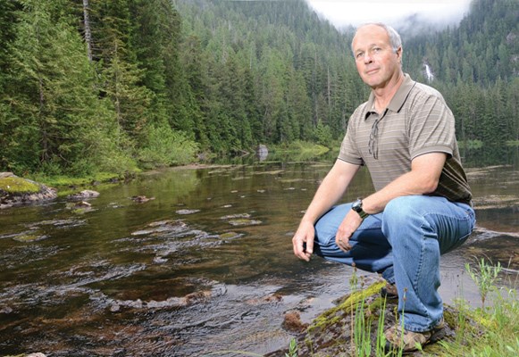 BOB Cavill, Metro Vancouver's watershed division manager, at Rodgers Lake in the Capilano watershed. A waterfall spilling down from the alpine Palisade Lake is visible in the background.