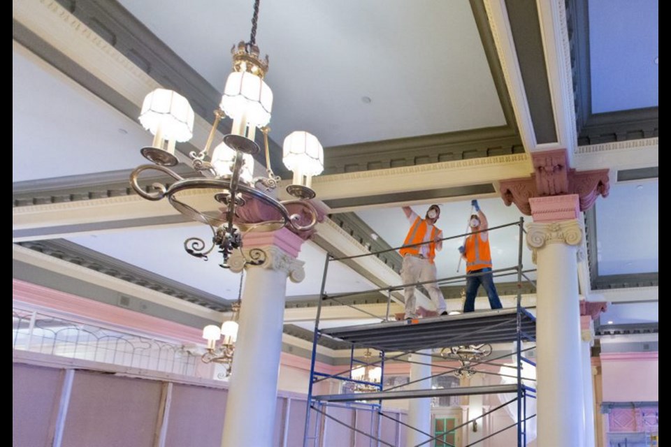 Construction crews scrape paint from the roof beams of the Empress Hotel's famed tea room, which is being transformed into a new lounge.