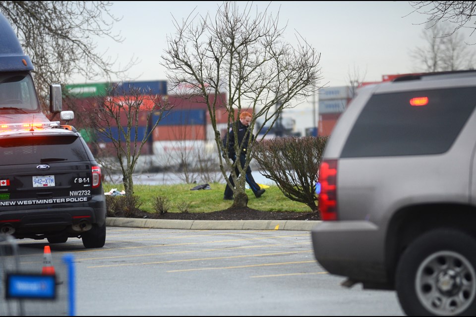 A New West police officer walks near the scene of a police-involved shooting at Queensborough Landing Friday.