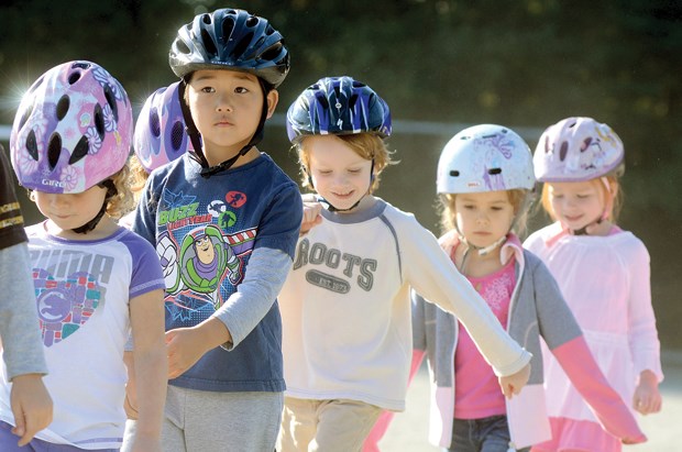 Ross Road elementary students Christian Young (second from left), Bjorn Mahony, Kate Carmichael and Chloe Thomas wait their turn on the road safety course set up by Escape Adventures at Ross Road elementary's Bike to School Week, Oct. 1-5.