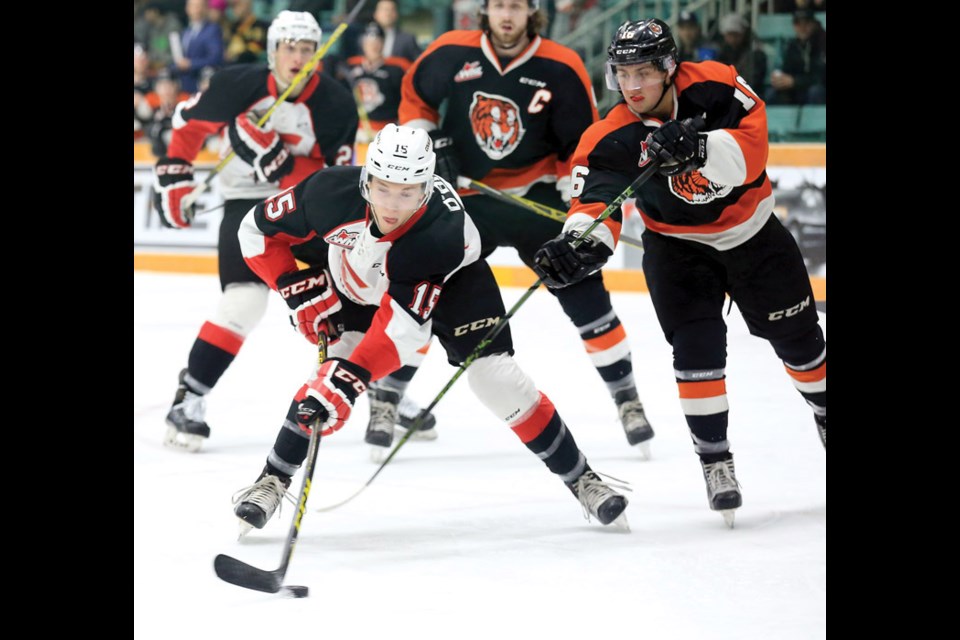 Prince George Cougars Brogan O'Brien puts a backhand shot on net while fighting off the check of Medicine Hat Tigers Max Gerlach on Monday. The Tigers were in Prince George for the first and only meeting between the two teams on CN Centre ice this season. Citizen Photo by James Doyle January 25, 2016