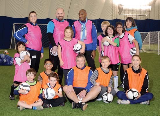The inaugural crop of Street Soccer for Everyone program participants team up for a photo with their coaches during the program's pilot run last fall.