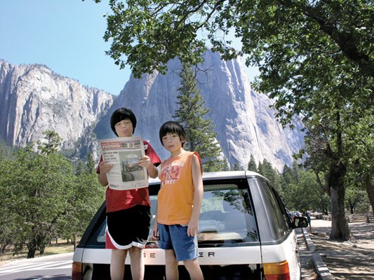 Antonio and Stefano Benzan stop to check out the News with El Capitan, a well-known vertical rock formation in Yosemite National Park, looming in the background.