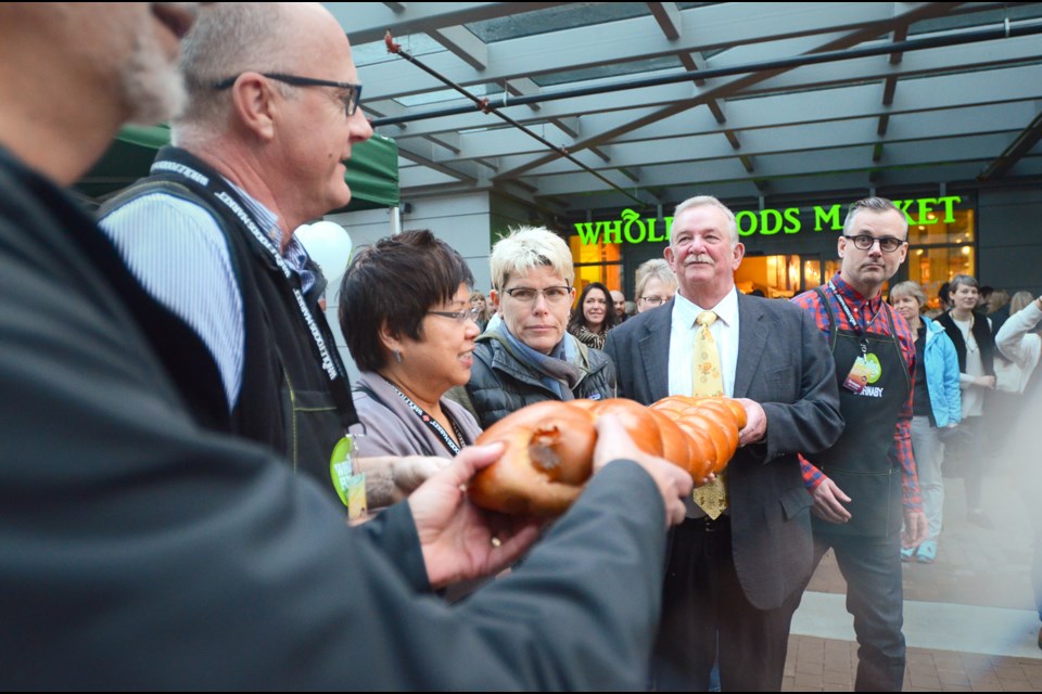 Burnaby Mayor Derek Corrigan, second from right, joins Burnaby Whole Foods Market officials in a bread-breaking ceremony at the store’s grand opening event Thursday morning.