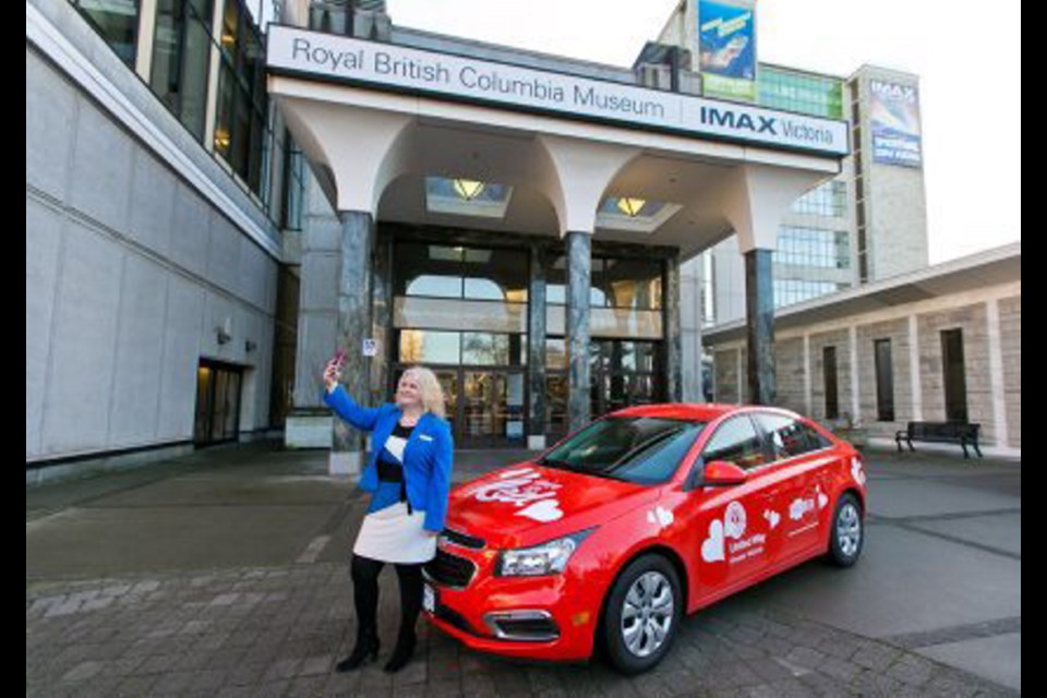 Heather Skydt takes a selfie with the Raise the Red "love" car at the Royal B.C. Museum during the launch of the United Way of Greater Victoria's new campaign. The initiative includes a number of events — and a photo contest. Prizes include a getaway to Wild Renfrew Seaside Cottages and a romance package from Silk Road Tea.