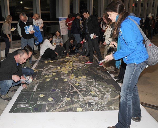 Residents including Rowena Tansley, right, place their views on what’s best and worst about Squamish on a large map at the visioning event held at the West Coast Railway Heritage Park last Thursday.