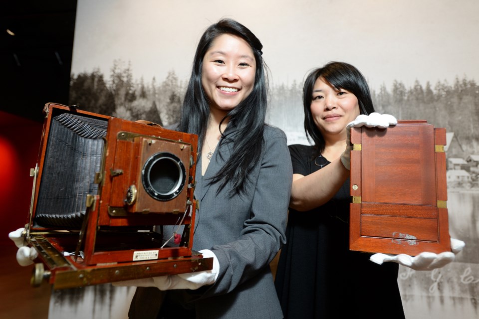 Michelle Taylor, heritage programmer for the City of New Westminster, holds a camera belonging to Paul Louis Okamura c. 190, and Cindy Mochizuki, lead artist for the Living Archive, with the film holder. They're looking for contemporary visual artists aged 17 to 24 to take part in a new installation.