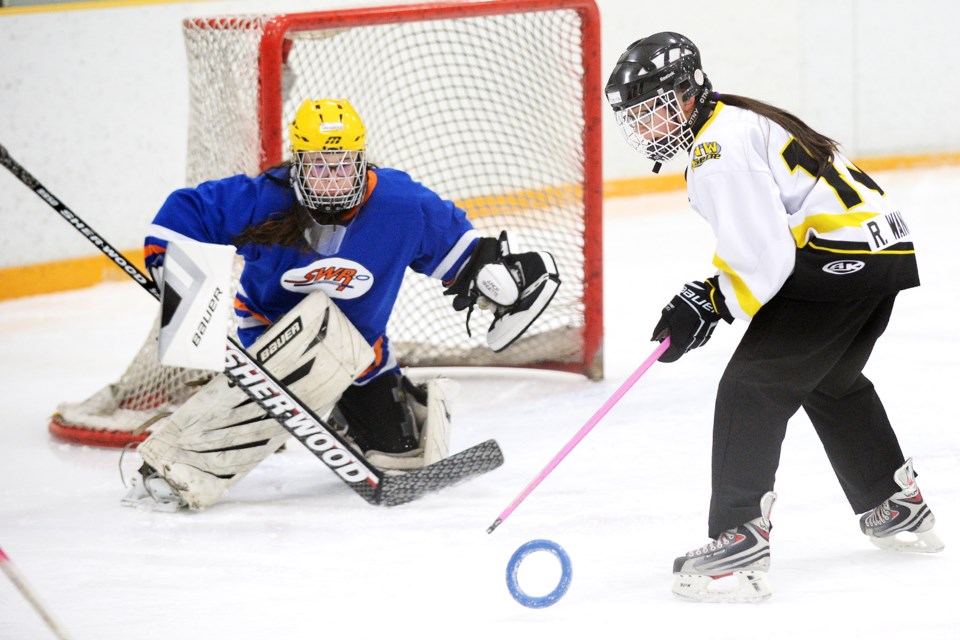 Burnaby-New West under-14 ringette’s Ratana Wang, right, tries to corral a pass to get a shot on the Surrey-White Rock net during last week’s provincial qualifier game at Burnaby Lake.